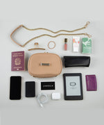 Load image into Gallery viewer, Collection of travel items including a crème caramel AVAIA Petit bag, phone, passport, and e-reader on a light gray background.