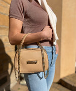 Load image into Gallery viewer, Person with an AVAIA Petit crème, using a padded chain strap, wearing it over their arm.