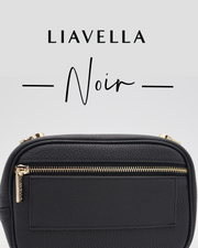 The back of a noir AVAIA Petit handbag with gold zipper on a light gray background, featuring the brand 'LIAVELLA'.