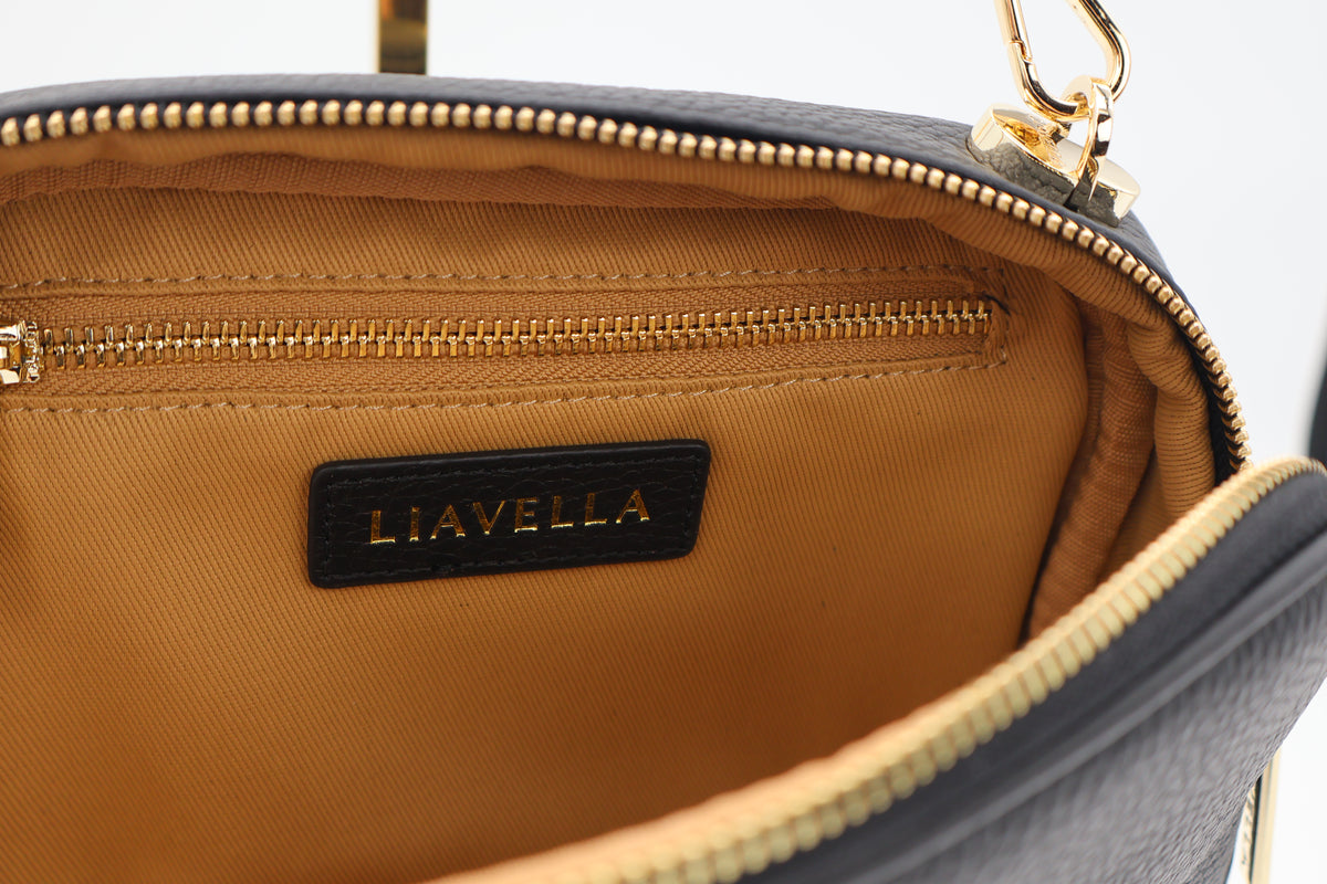 Close-up of a LIAVELLA bag with a gold zipper and beige interior.