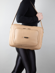 A person wearing a crème caramel AVAIA as a shoulder bag, using a long leather strap.