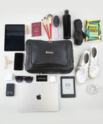 Load image into Gallery viewer, Collection of travel items including a black AVAIA bag, tablet, phone, laptop, and various personal items on a white background.