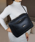 Load image into Gallery viewer, A person in a grey sweater wearing an AVAIA bag in front of her body.
