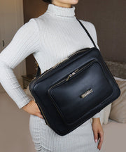 A person in a grey sweater wearing an AVAIA bag in front of her body.