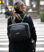 Load image into Gallery viewer, Woman wearing a AVAIA Noir as a backpack on a city street