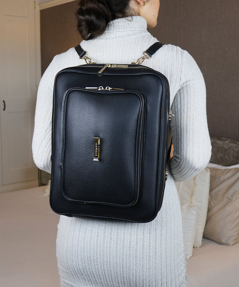 Person wearing the AVAIA bag as a vertical backpack indoors.