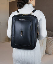 Person wearing the AVAIA bag as a vertical backpack indoors.