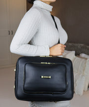 Woman wearing the AVAIA bag as a crossbody with a visible brand logo 