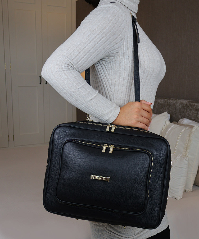 Woman wearing the AVAIA bag with a narrow shoulder strap in a badroom setting.