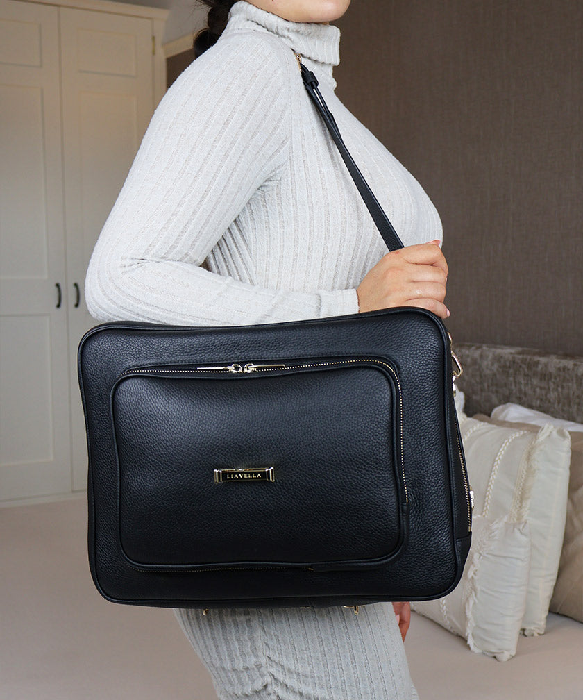 Woman in an indoor setting wearing the AVAIA bag over the shoulder.