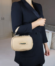 Woman wearing a black blazer with the AVAIA Petit over her arm in an indoor room.