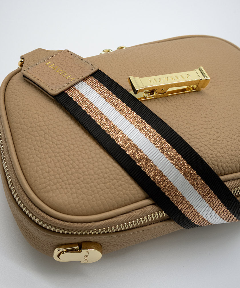 The AVAIA Petit bag with a striped strap on a light gray background.