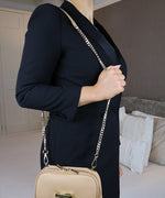 Load image into Gallery viewer, Woman with an over the shoulder bag featuring a gold chain strap in an indoor setting.
