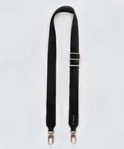 Adjustable, black fabric bag strap with gold hardware on a white background.