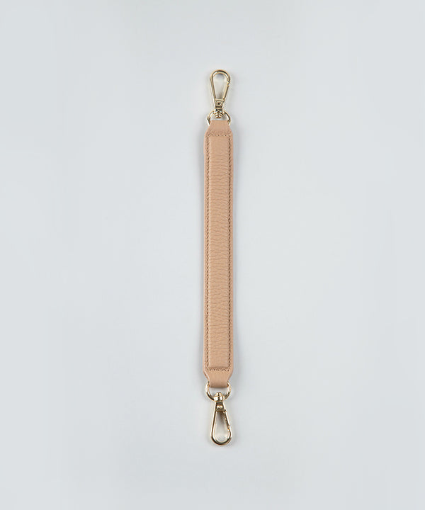 Crème caramel handheld strap on a white studio background