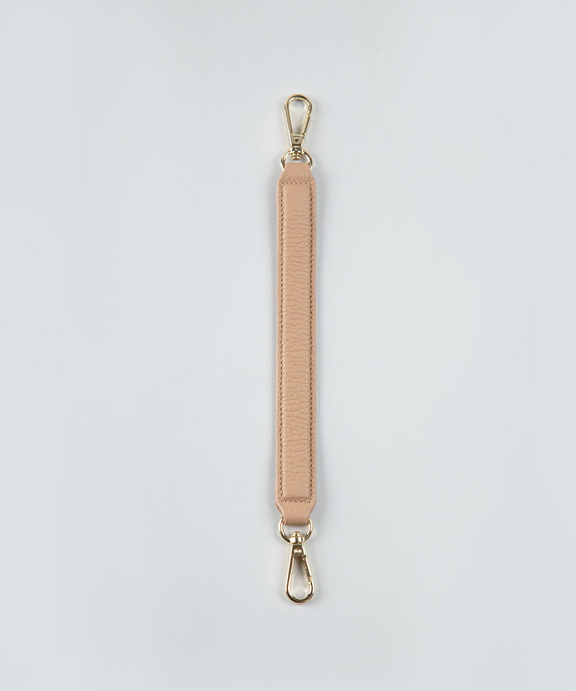 Crème caramel handheld strap on a white studio background