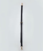Load image into Gallery viewer, Black bag strap with gold hardware on a light gray background