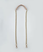 Load image into Gallery viewer, Gold chain strap with a leather handle against  a light gray background.
