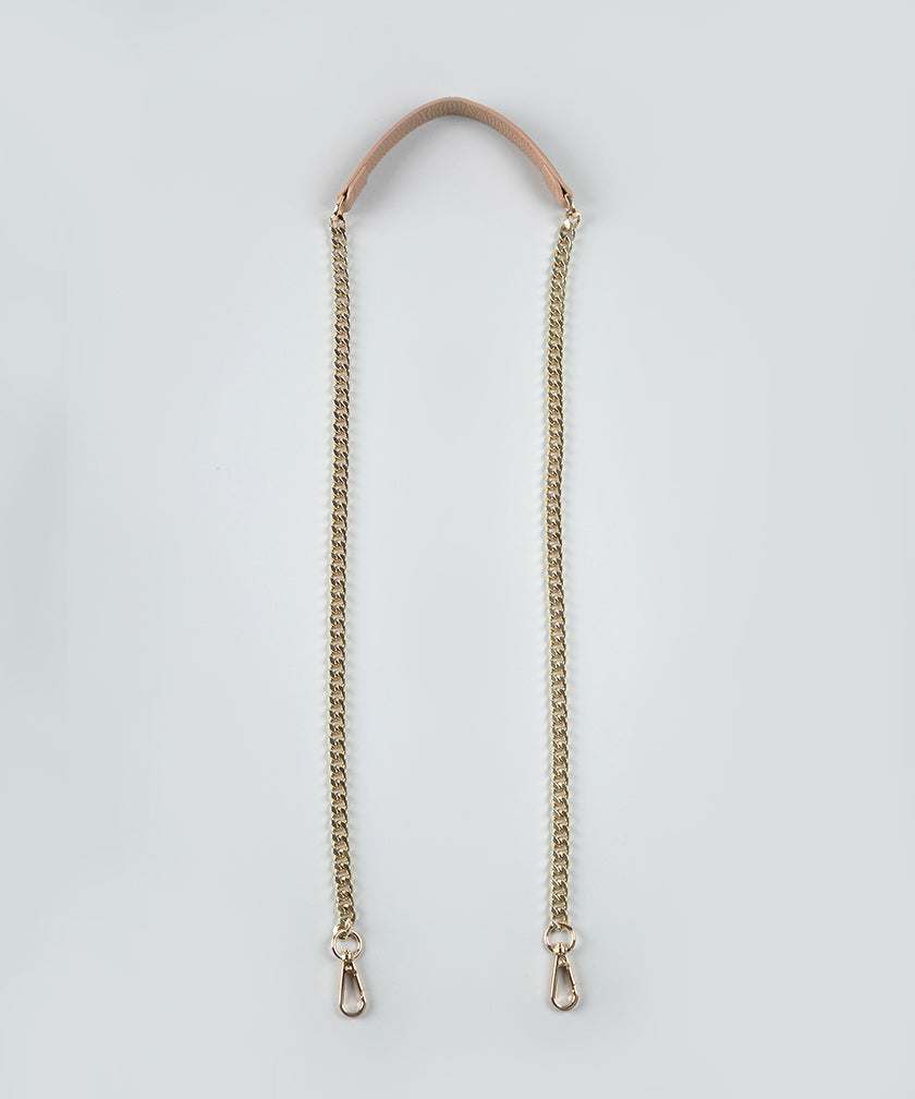 Gold chain strap with a leather handle against  a light gray background.