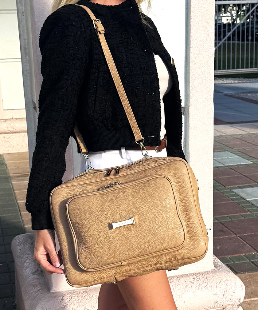 Person wearing a shoulder bag AVAIA in crème caramel with a blurred background