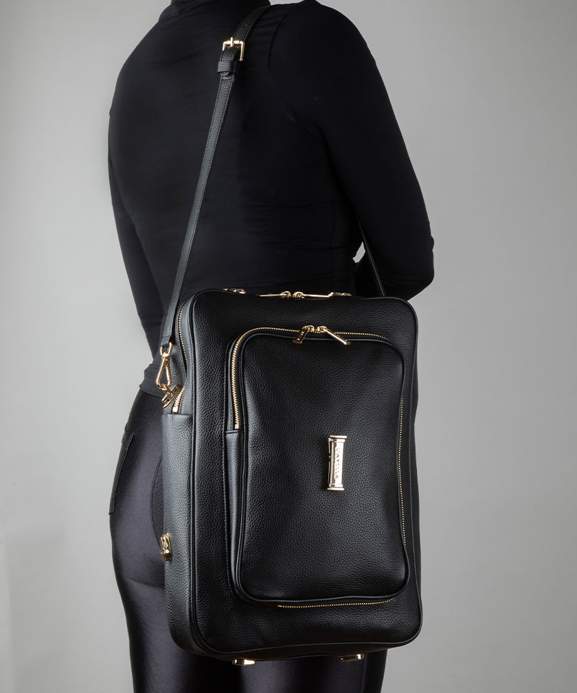 AVAIA bag Noir shoulder bag with gold accents on a gray background