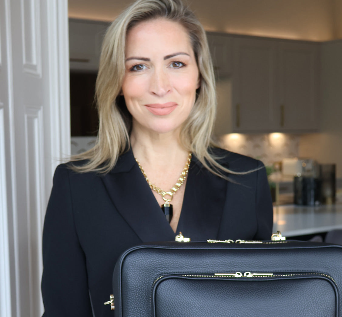 Woman holding a black AVAIA bag in a kitchen setting